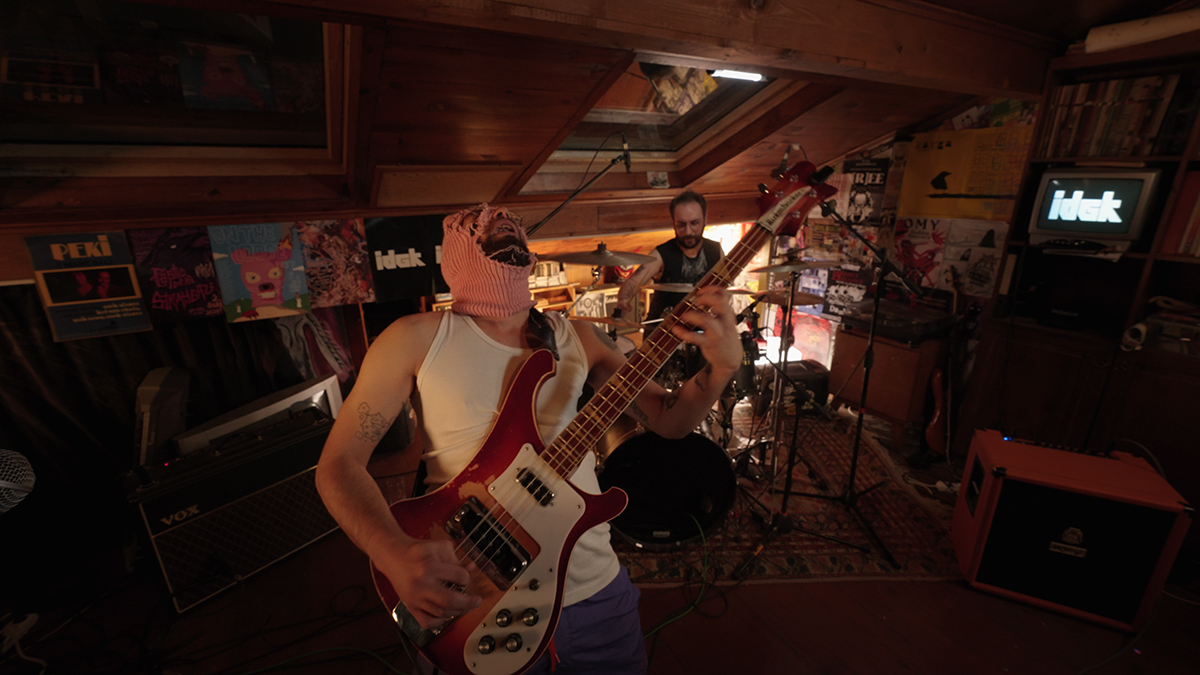 A performance of a duo on bass guitar and drums captured in the Yuva performance space